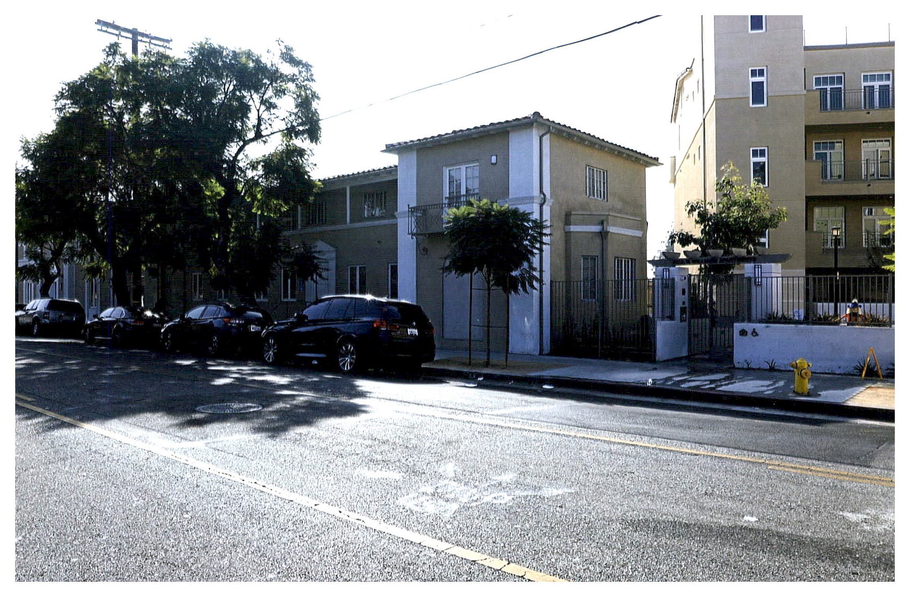 After: oblique view of other side of street facade showing proximity to new four floor apartment building new construction on site.
