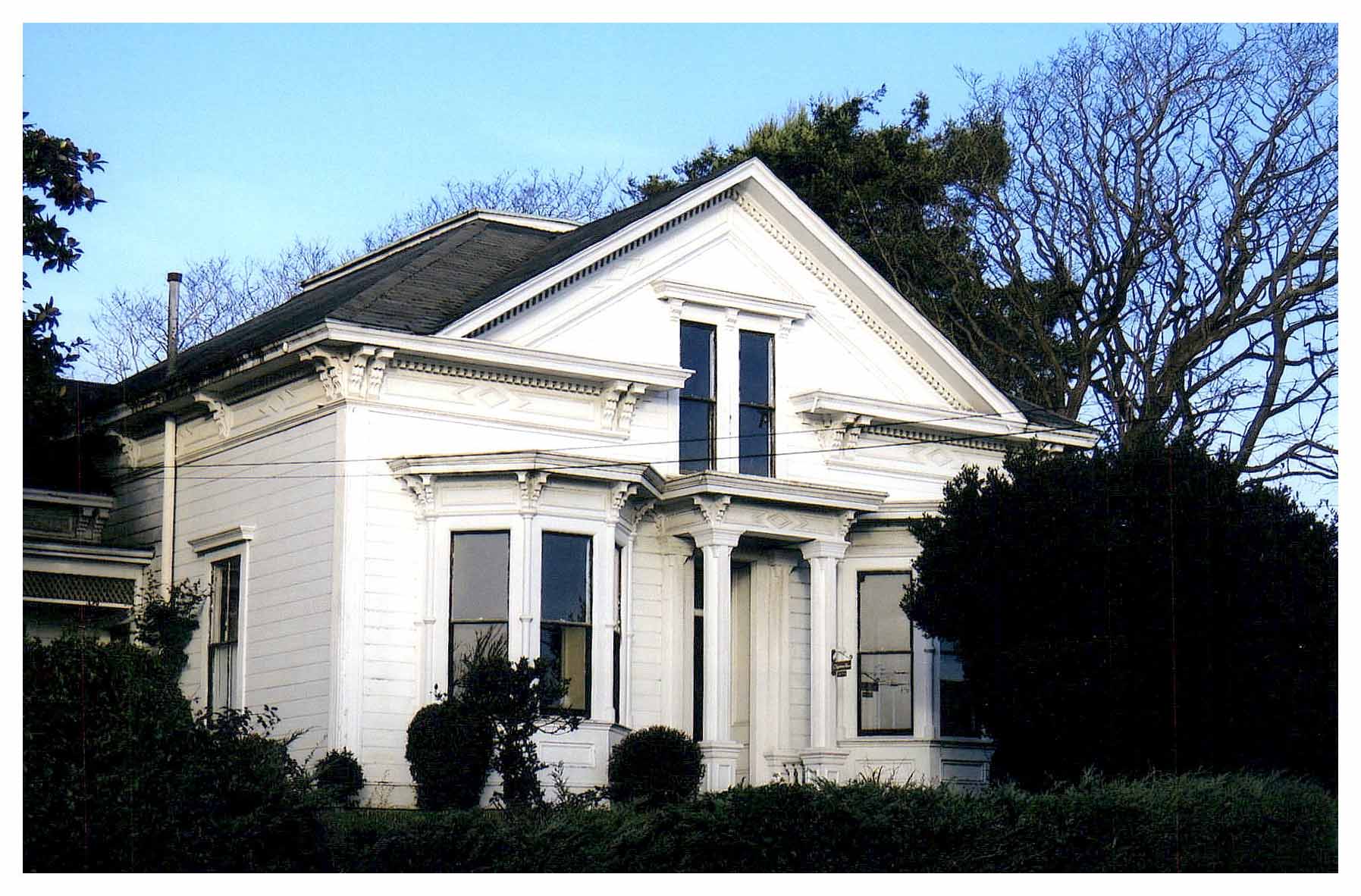 Before: view of untreated front with obscuring landscaping.