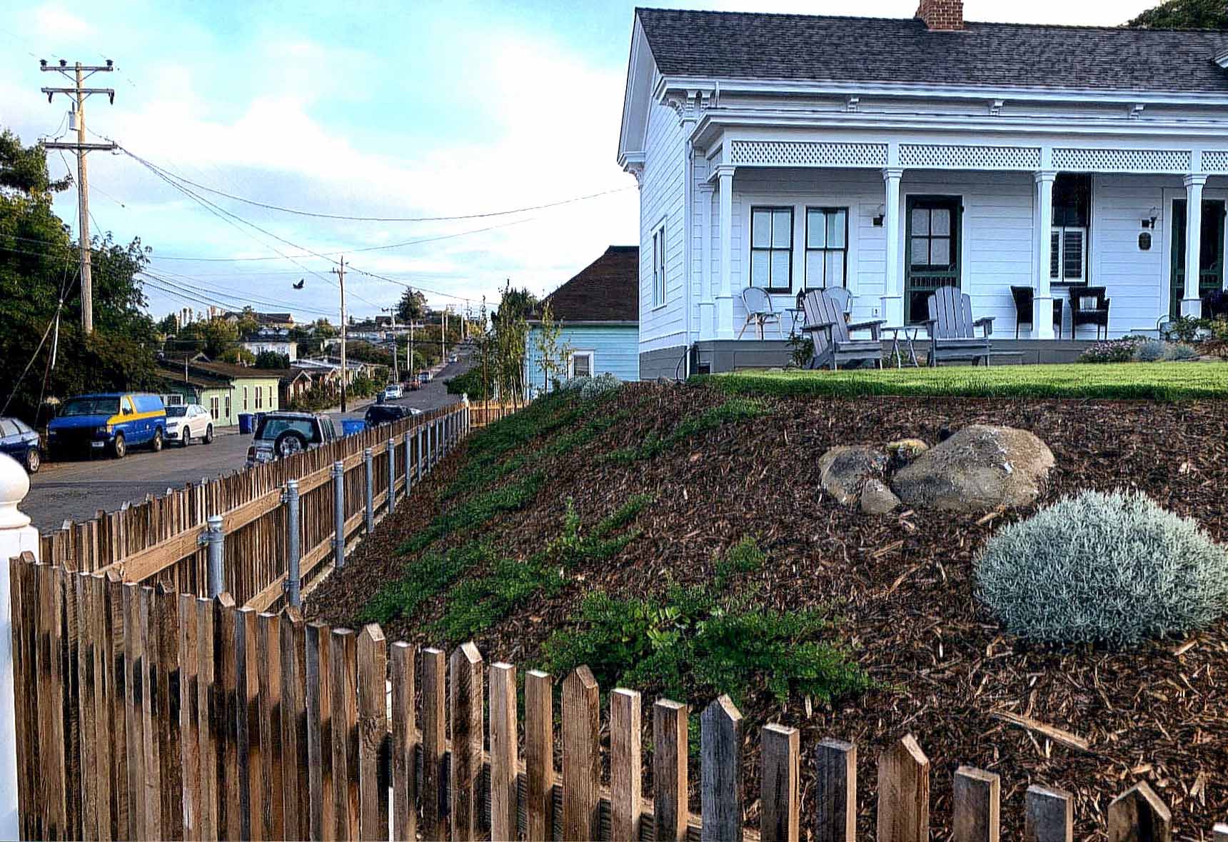 After: view of front yard with new fencing, low plantings and apartment wing.
