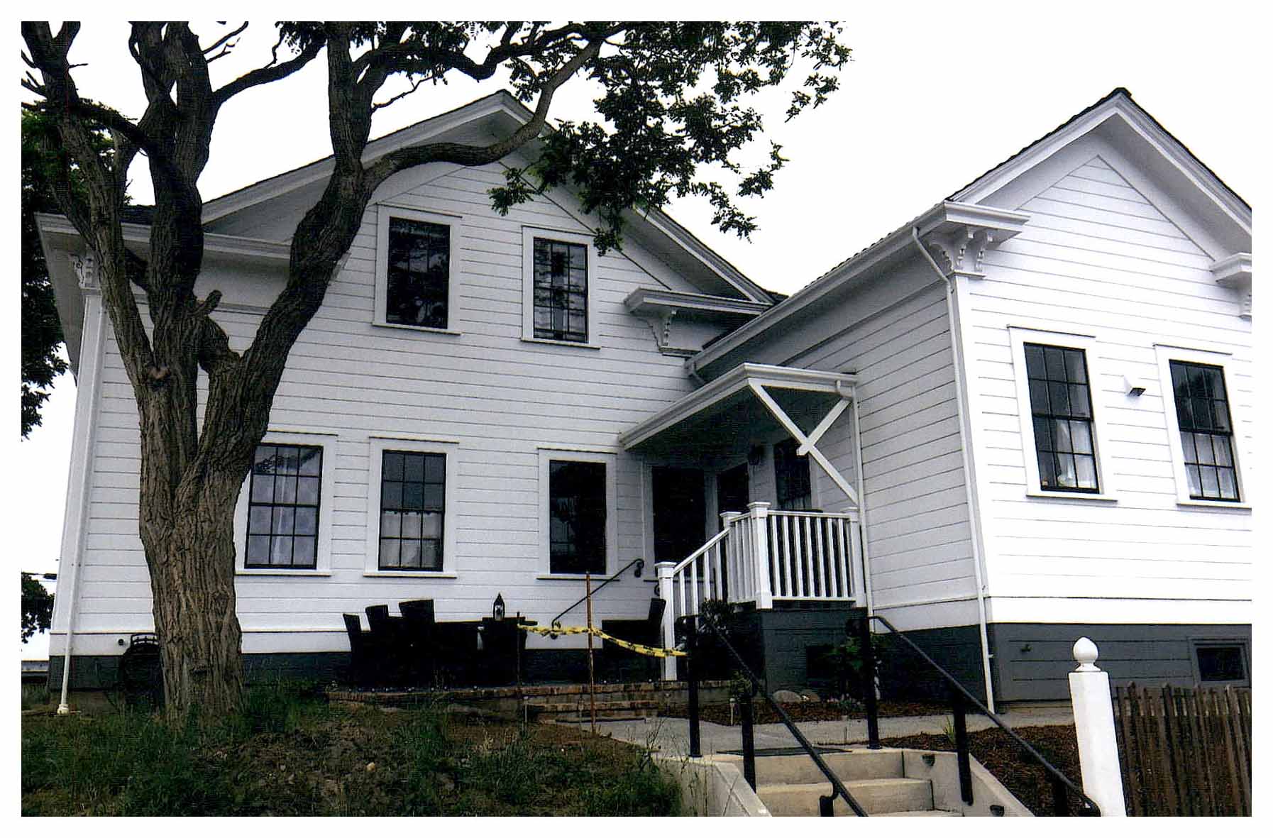 After: white painted rear facade showing restored porch and windows.