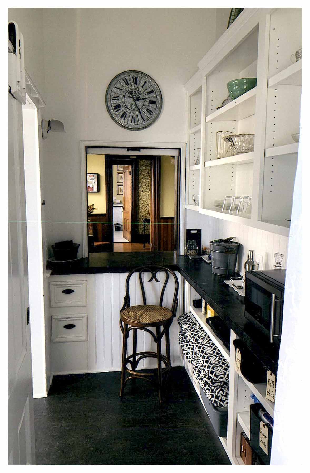 After:  other side of retractable sash showing Butler's pantry with counters and cabinet storage. Sash is open, revealing the dining room beyond.