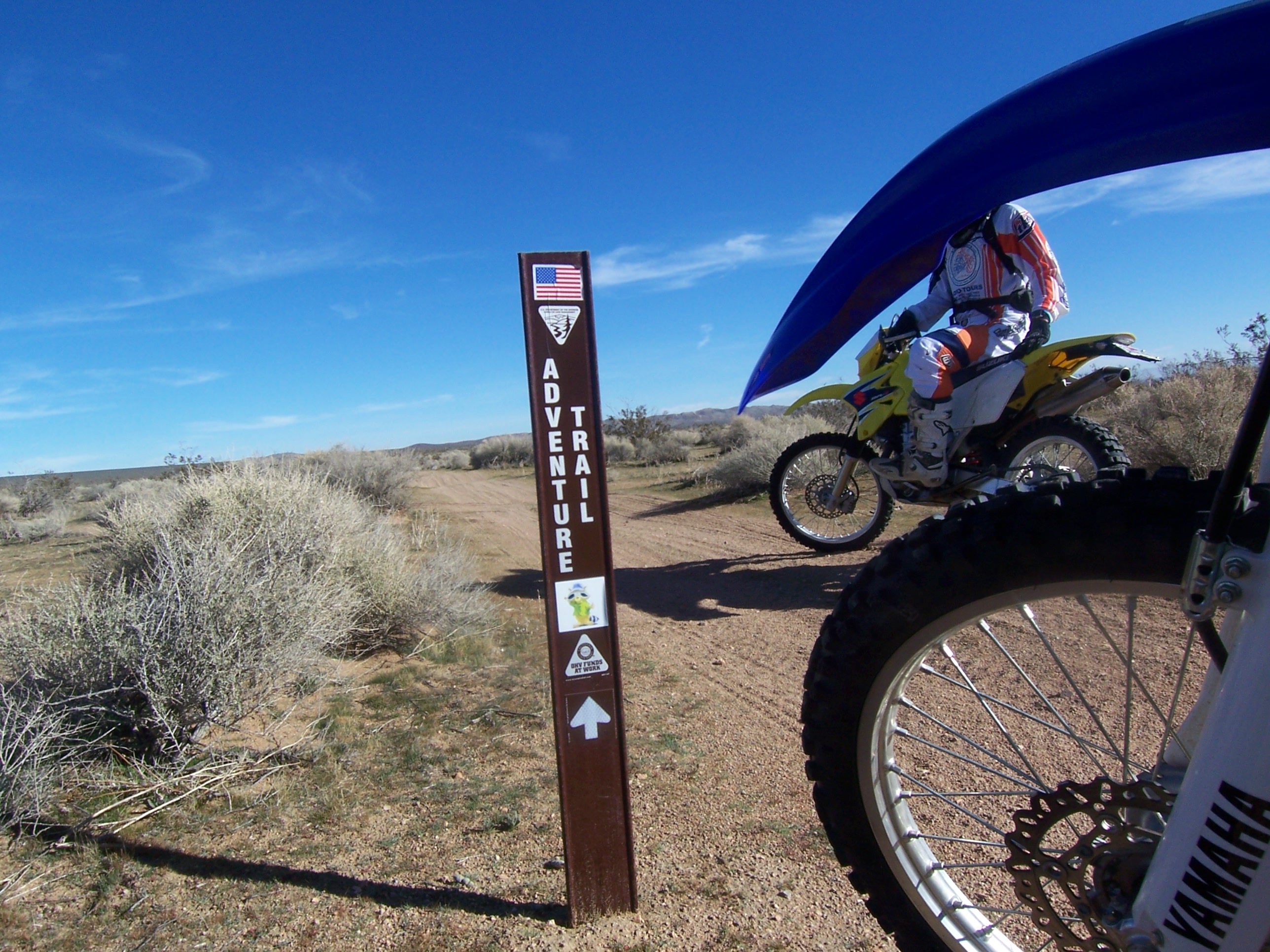 dirt bike on trail with carsonite sign