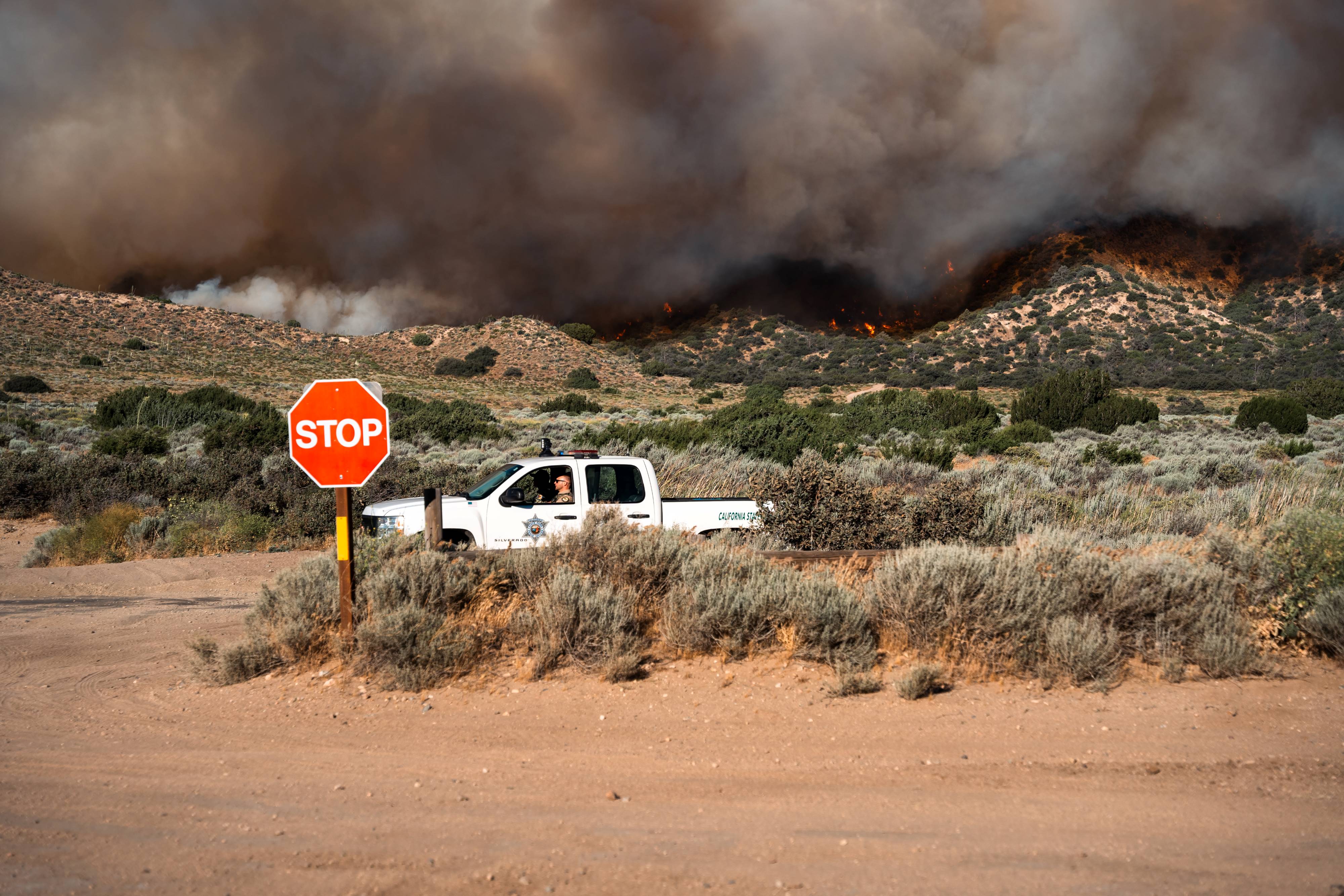 A State Park Ranger in his patrol vehicle parked on Gold Hill Road assists with the evacuation of Hungry Valley SVRA.
