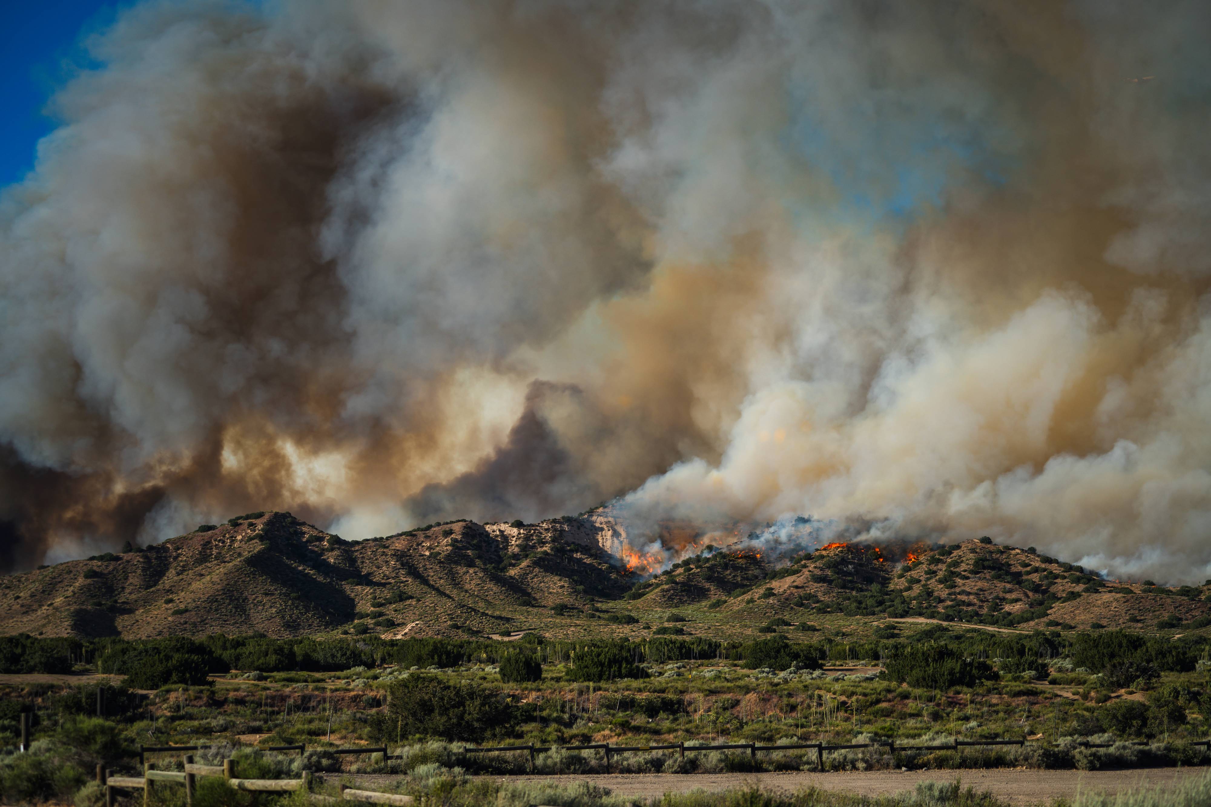 Flames and smoke from the Post Fire are visible on a ridge in the eastern portion of Hungry Valley SVRA.