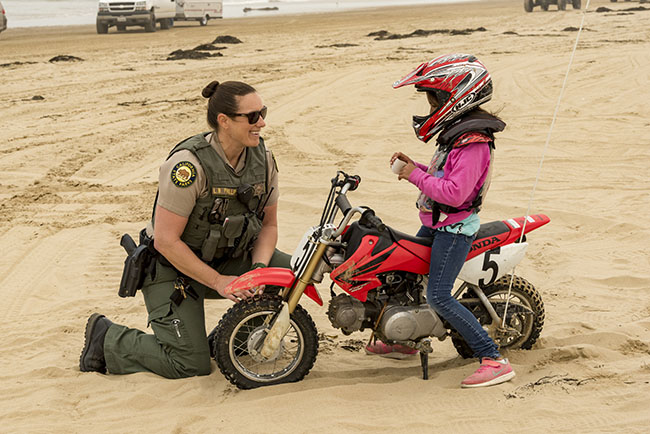 Child on ATV talking with Ranger