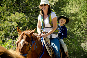 Woman and boy riding a horse during the day.