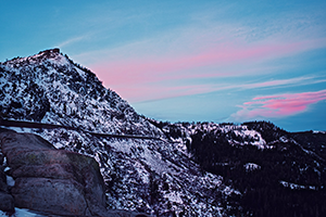 Mountain range, laid with snow at dusk.