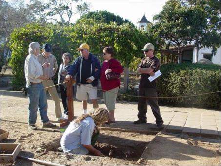 Figure 8, Archaeology work in progress at Unit S30-35/E-10-15, with M. Buxton excavating and M. Sampson talking to park visitors. Photo taken November 2007.