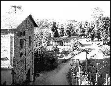 View of the north face of Powerhouse and blacksmith shop from top of forebay