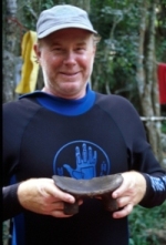 John Foster holding a carved wooden stool or "duho."