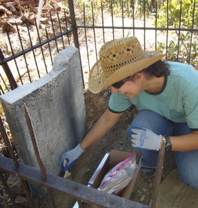 Cleaning a grave site at Shasta SHP Catholic Cemetery