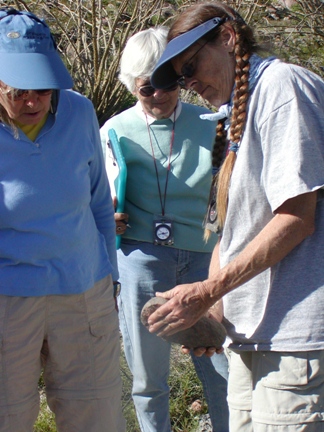 Stewards identify ground stone artifacts.