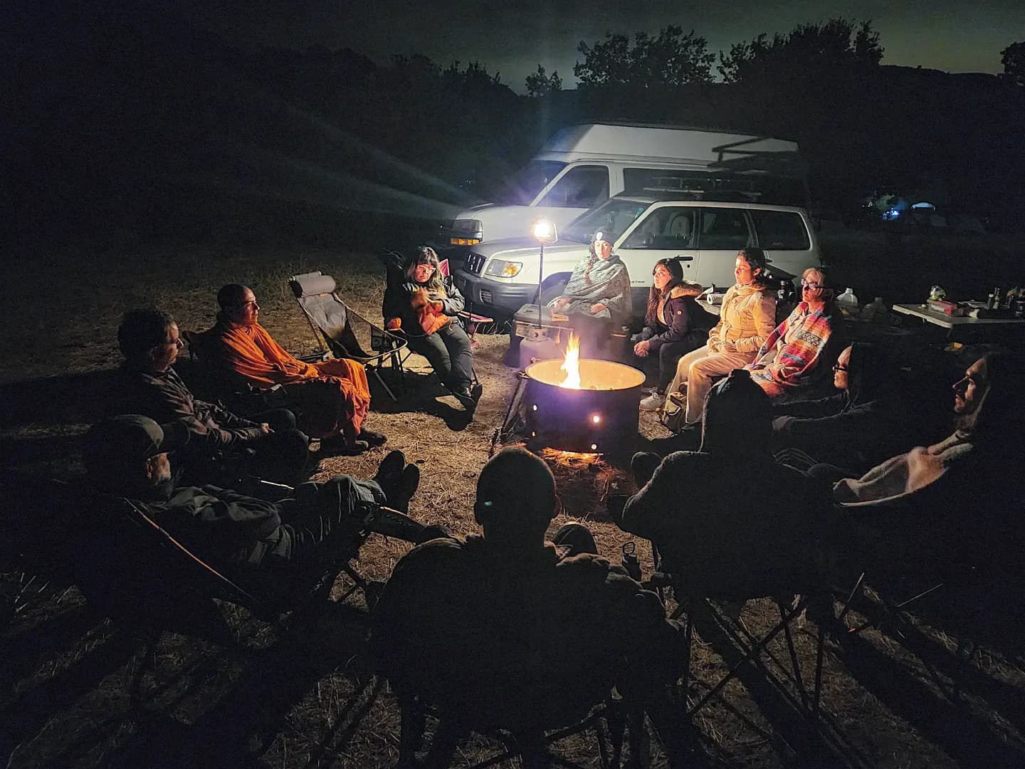 group of people sitting around a campfire