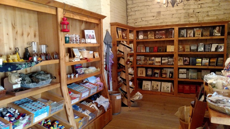 view of a retail space with wooden display shelves stocked with various wares: books, souvenirs, toys