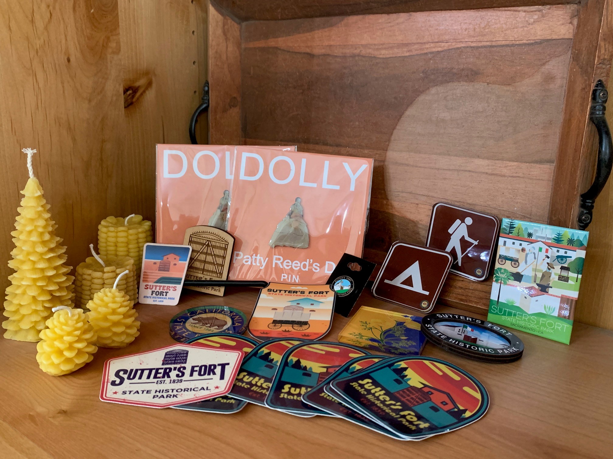 retail display shelf featuring various keepsakes: stickers, pins, candles, magnets