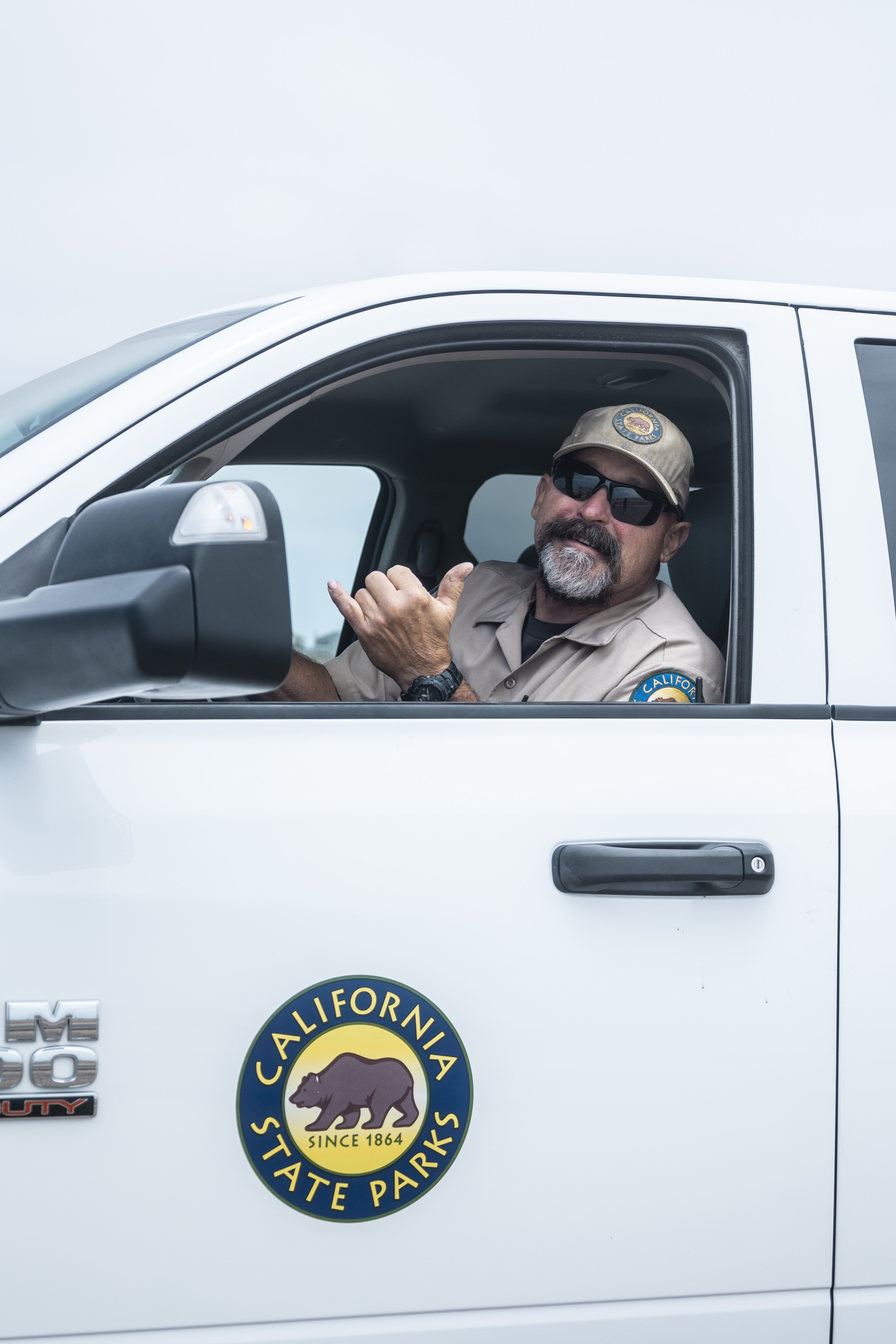 Park maintenance worker smiles at the camera in a maintenance truck.