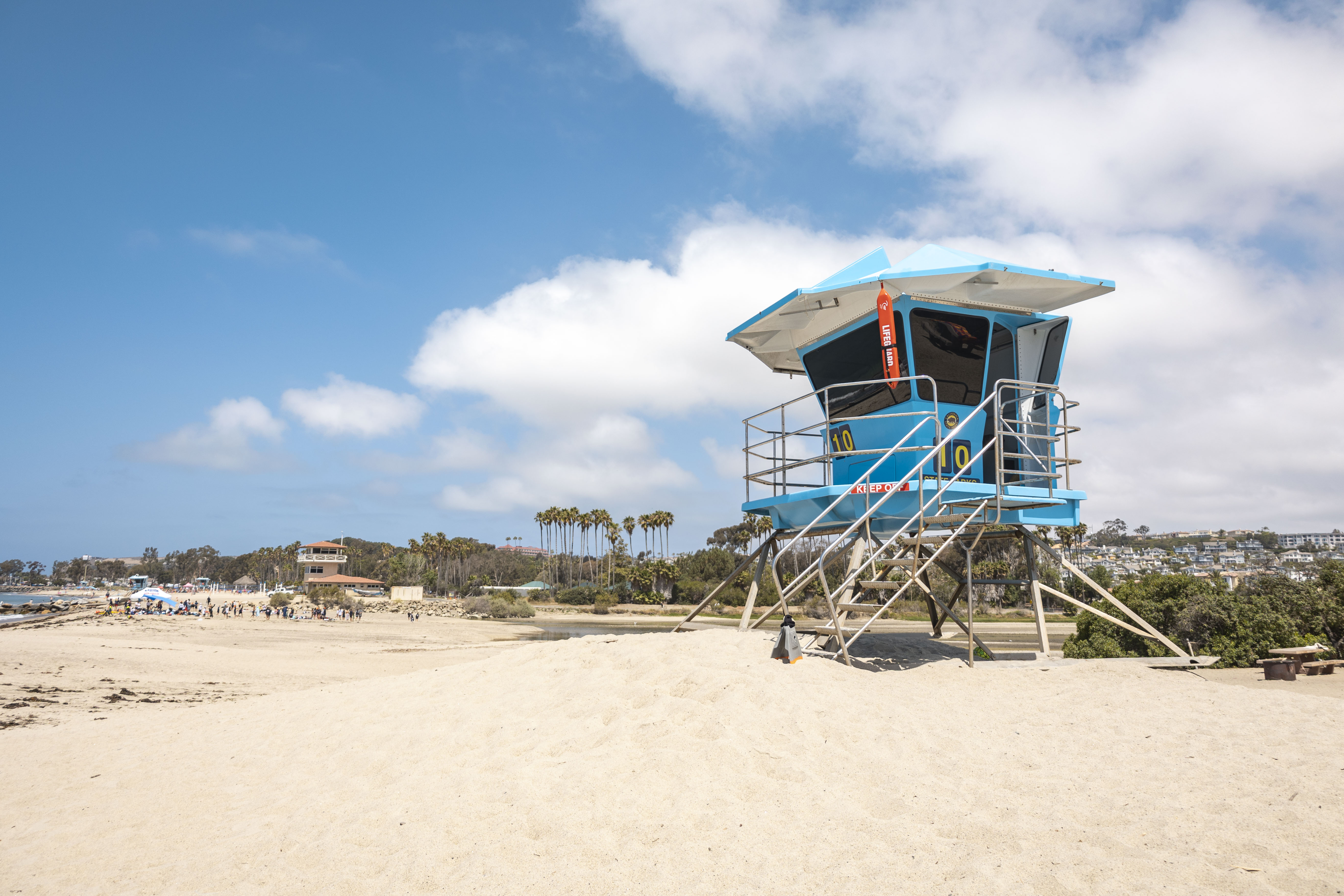 A lifeguard tower labelled 10 sits on the sand in front of the ocean
