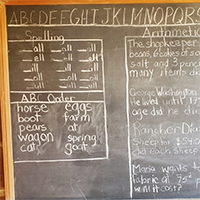 Historic chalk board with lesson plans written in chalk on it