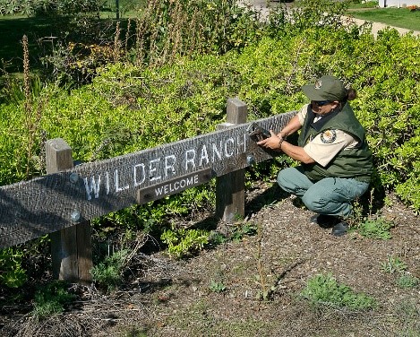 Parks worker fixing sign