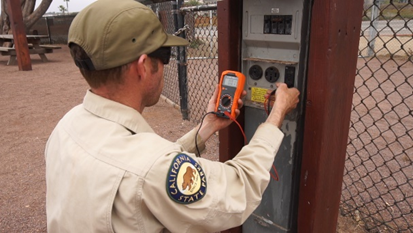 Parks worker using voltmeter